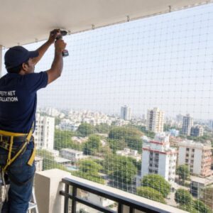 Technician installing balcony safety net in a high-rise apartment building for child safety, pet protection, and pigeon prevention in Bangalore