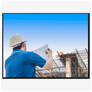Construction engineer wearing safety helmet reviewing building plans at a construction site